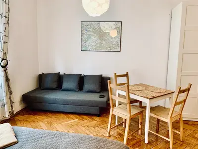 a bedroom with a table and chairs and a couch at Studio in Center in Kraków