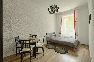 a bedroom with a bed and a table and chairs at Apartament w centrum :) in Kraków