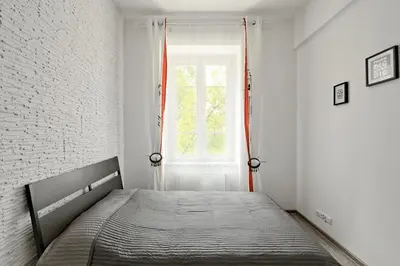 a bed in a white room with a window at Apartament w centrum :) in Kraków