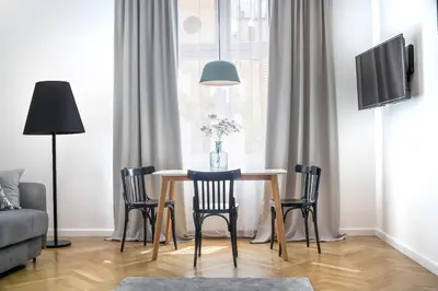 a dining room table with chairs and a tv at Wanderlust Apartments in Kraków