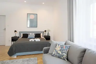 a bedroom with a bed and a couch at Wanderlust Apartments in Kraków