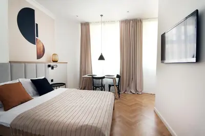 a bedroom with a bed and a table with chairs at Wanderlust Apartments in Kraków