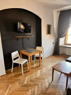 a living room with a wooden table and chairs at Main Square 18 view 1 in Kraków