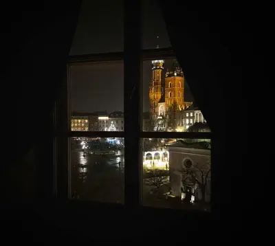 a view of a city from a window at night at Main Square 18 view 1 in Kraków