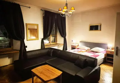 a living room with a couch and a bed at Main Square 18 view 1 in Kraków