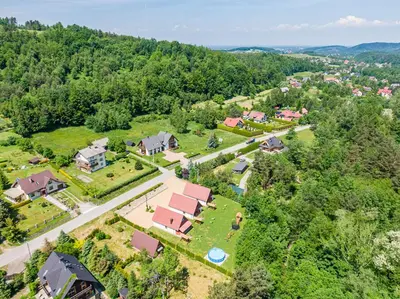 an aerial view of a village with houses and trees at Domki Pod Czarnym Groniem in Rzyki