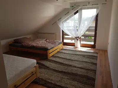 a attic room with two beds and a window at DOM W GÓRACH in Maków Podhalański