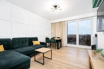 a living room with a green couch and a table at Kraków City Center Luxury Apartment in Kraków