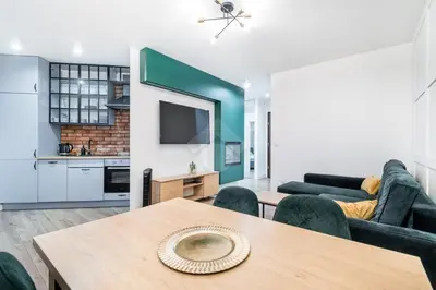 a living room with a table and a kitchen at Kraków City Center Luxury Apartment in Kraków