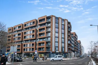 a large brick building on a city street with cars at Kraków City Center Luxury Apartment in Kraków