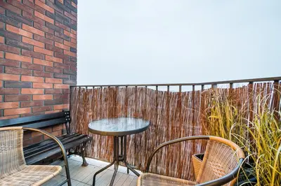 a patio with a table and chairs and a fence at Kraków City Center Luxury Apartment in Kraków