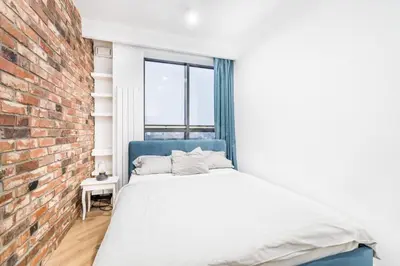 a bedroom with a bed and a brick wall at Kraków City Center Luxury Apartment in Kraków