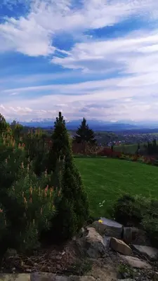 a grassy hill with a field and trees in the background at Widokowa Chata in Obidowa