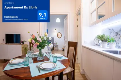 a table with plates and flowers on it in a kitchen at Apartament Ex Libris in Kraków