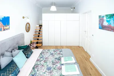 a bedroom with a bed with a rug on the floor at Apartament Ex Libris in Kraków