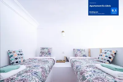 two beds sitting next to each other in a room at Apartament Ex Libris in Kraków
