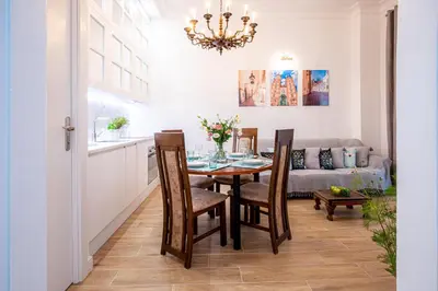 a dining room with a table and chairs and a couch at Apartament Ex Libris in Kraków