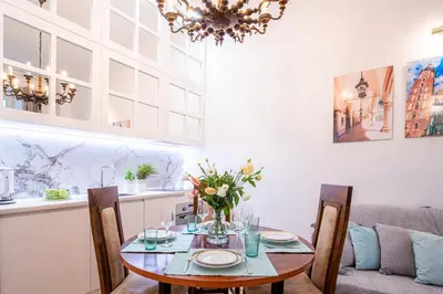 a dining room with a table and chairs and a chandelier at Apartament Ex Libris in Kraków