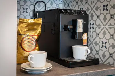 two coffee cups on a counter next to a coffee maker at WawelSee Apartments in Kraków