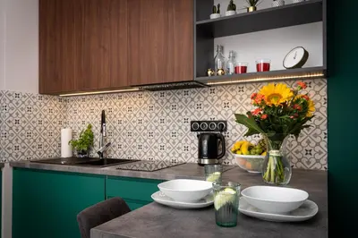 a kitchen with a table with a vase of flowers at WawelSee Apartments in Kraków