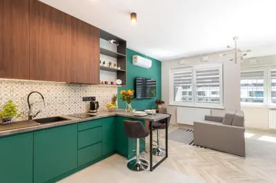 a kitchen with turquoise cabinets and a counter top at WawelSee Apartments in Kraków