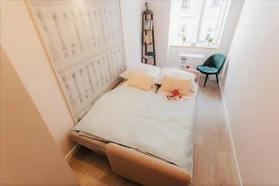 a small bed in a small room with a window at DeLux Apartament OldTown Kochanowskiego 30 Kraków in Kraków