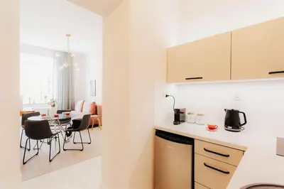 a kitchen and living room with a table and chairs at DeLux Apartament OldTown Kochanowskiego 30 Kraków in Kraków