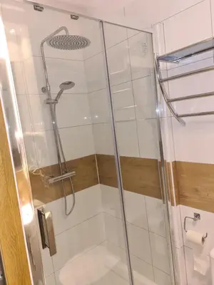 a shower with a glass door in a bathroom at AMBER APARTAMENt 10 in Kraków