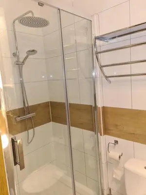 a shower with a glass door in a bathroom at AMBER APARTAMENt 10 in Kraków