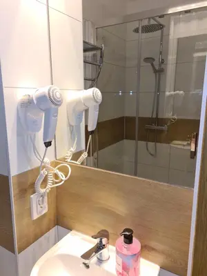 a bathroom with a sink and a mirror and a shower at AMBER APARTAMENt 10 in Kraków