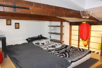 a bedroom with a large bed with a black and white comforter at Samurai - Old Town, Main Square, Main station in Kraków