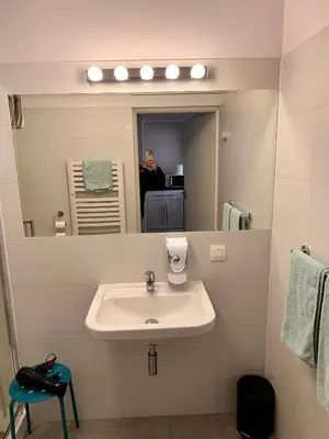 a bathroom with a sink and a mirror at Family Apartament in Kraków