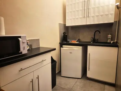 a small kitchen with a microwave and a refrigerator at Family Apartament in Kraków