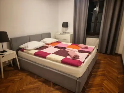 a bedroom with a bed with a striped blanket at Family Apartament in Kraków