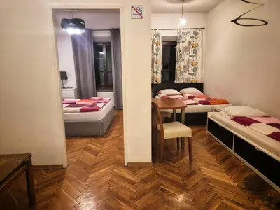 a room with two beds and a table in it at Family Apartament in Kraków