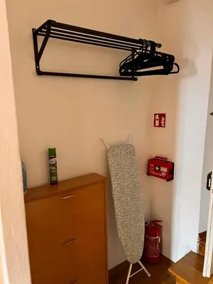 a room with a shelf and a dresser with a chair at Family Apartament in Kraków