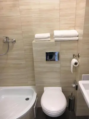 a bathroom with a white toilet and a sink at Piast Hotele Studenckie in Kraków