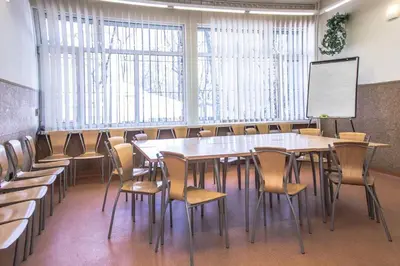 a classroom with a table and chairs and a whiteboard at Piast Hotele Studenckie in Kraków