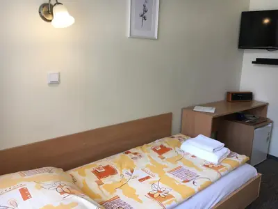 a hotel room with a bed with a blanket on it at Piast Hotele Studenckie in Kraków