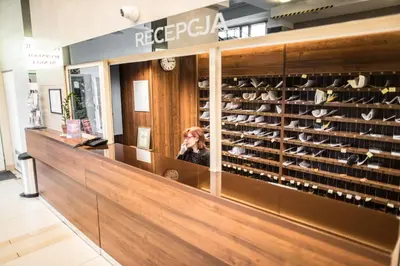a woman is sitting in a shoe shop at Piast Hotele Studenckie in Kraków