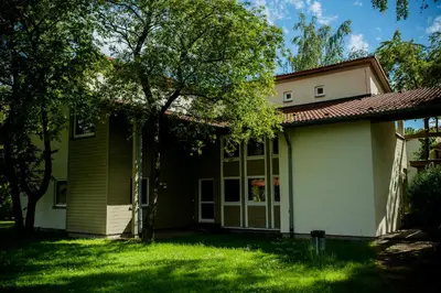 a house with a green lawn and a tree at Międzynarodowy Dom Spotkań Młodzieży w Oświęcimiu in Oświęcim