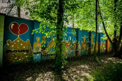 a wall covered in graffiti with a heart painted on it at Międzynarodowy Dom Spotkań Młodzieży w Oświęcimiu in Oświęcim
