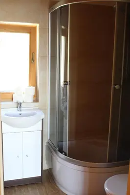a bathroom with a shower and a sink at Domki Karczma Zbójnicka in Wiśniowa