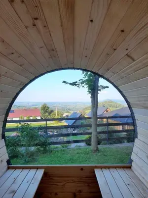 an arched window in a wooden building with a tree at Domki Karczma Zbójnicka in Wiśniowa