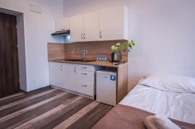 a small kitchen with a sink and a bed in a room at Willa Zator in Oświęcim