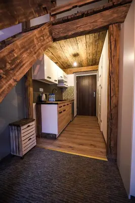 an open hallway with a kitchen with wooden beams at Willa Zator in Oświęcim