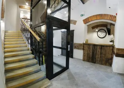 a hallway with a staircase with a clock on the wall at Willa Zator in Oświęcim