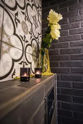 a table with two candles and a vase with flowers at Willa Zator in Oświęcim