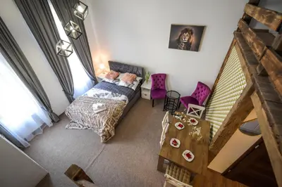 a bedroom with a bed and two purple chairs at Willa Zator in Oświęcim