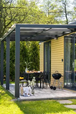 a pergola over a patio with a table and chairs at ZATORHOUSE in Zator